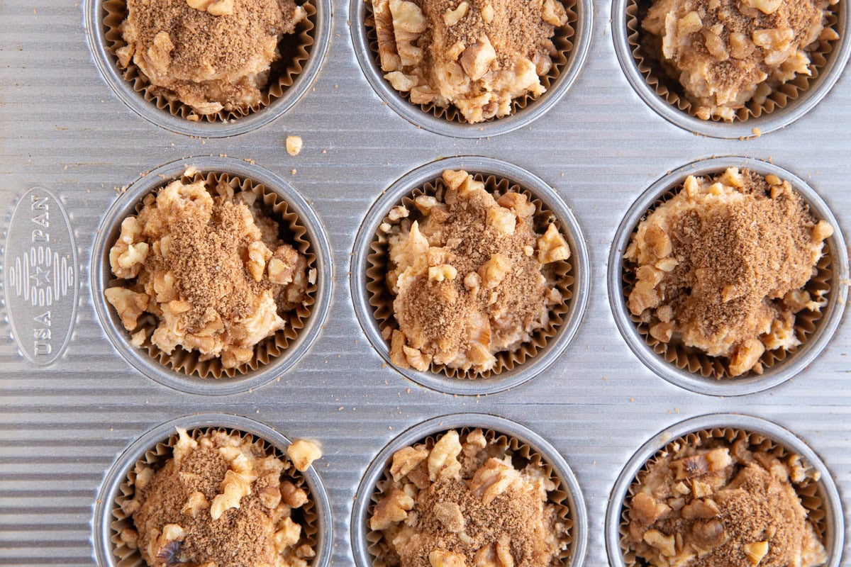 Muffin tray full of coffee cake muffin batter.