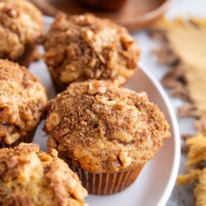 White plate with coffee cake muffins on top, ready to serve.