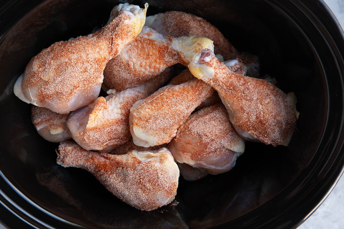 Drumsticks seasoned with dry rub in a slow cooker.