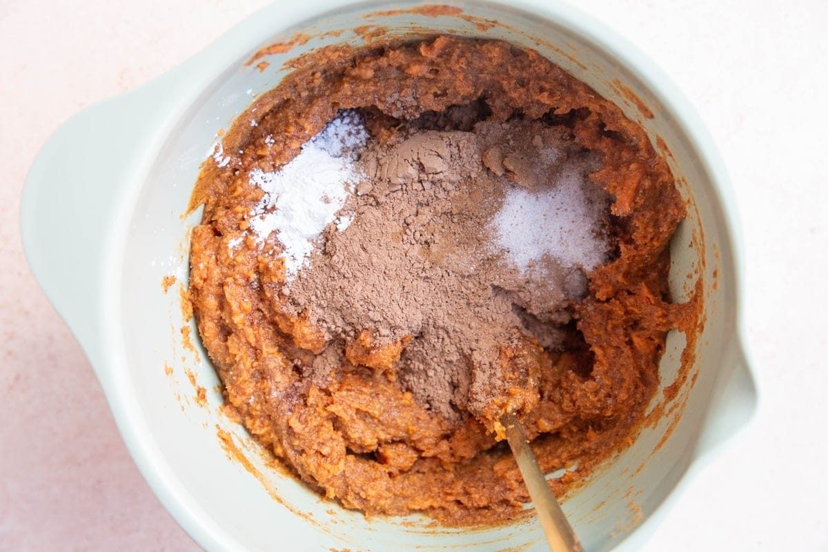 Dry ingredients on top of wet ingredients in a mixing bowl.