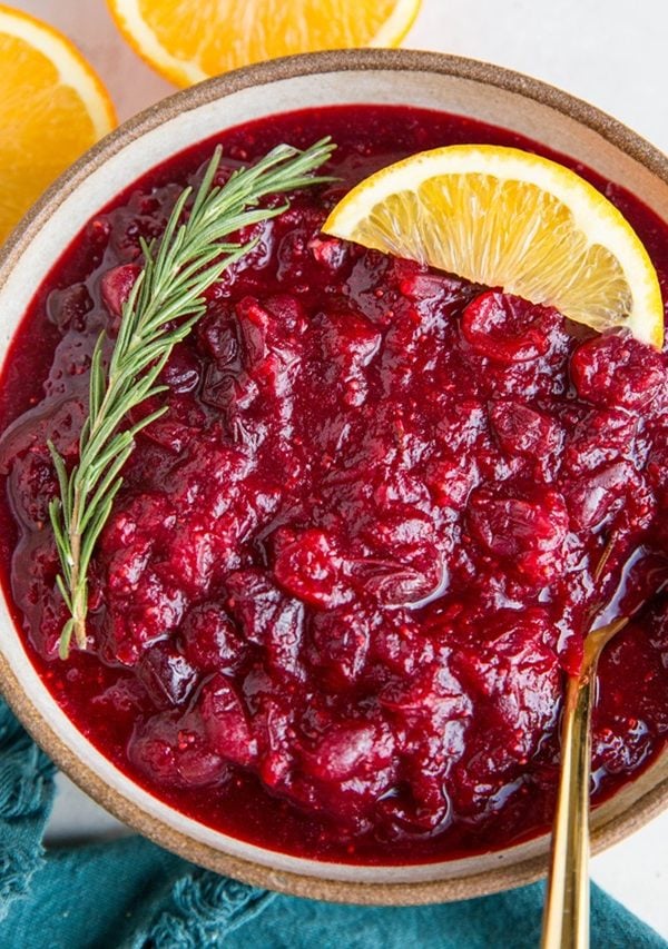 orange ginger cranberry sauce in a bowl with a spoon.