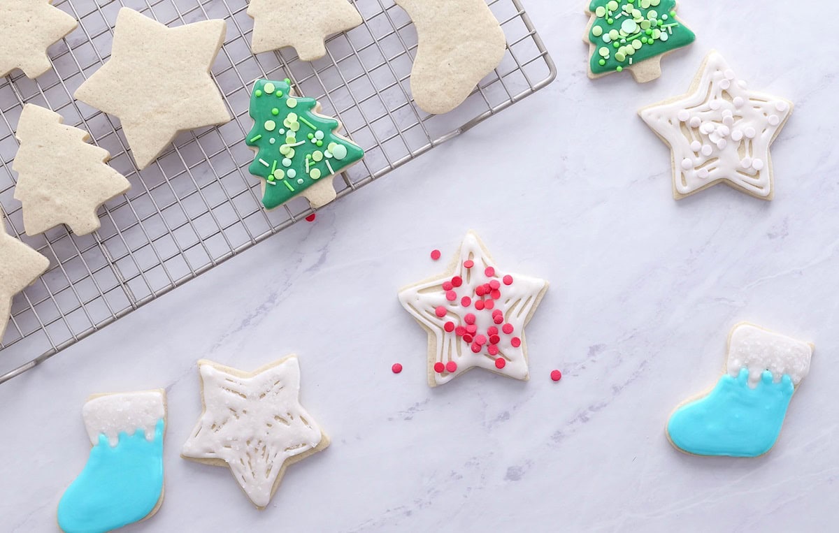 Scattered sugar cookies on a marble surface.