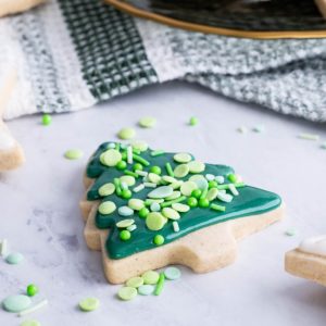 gluten-free sugar cookies on a marble surface, decorated into Christmas shapes.