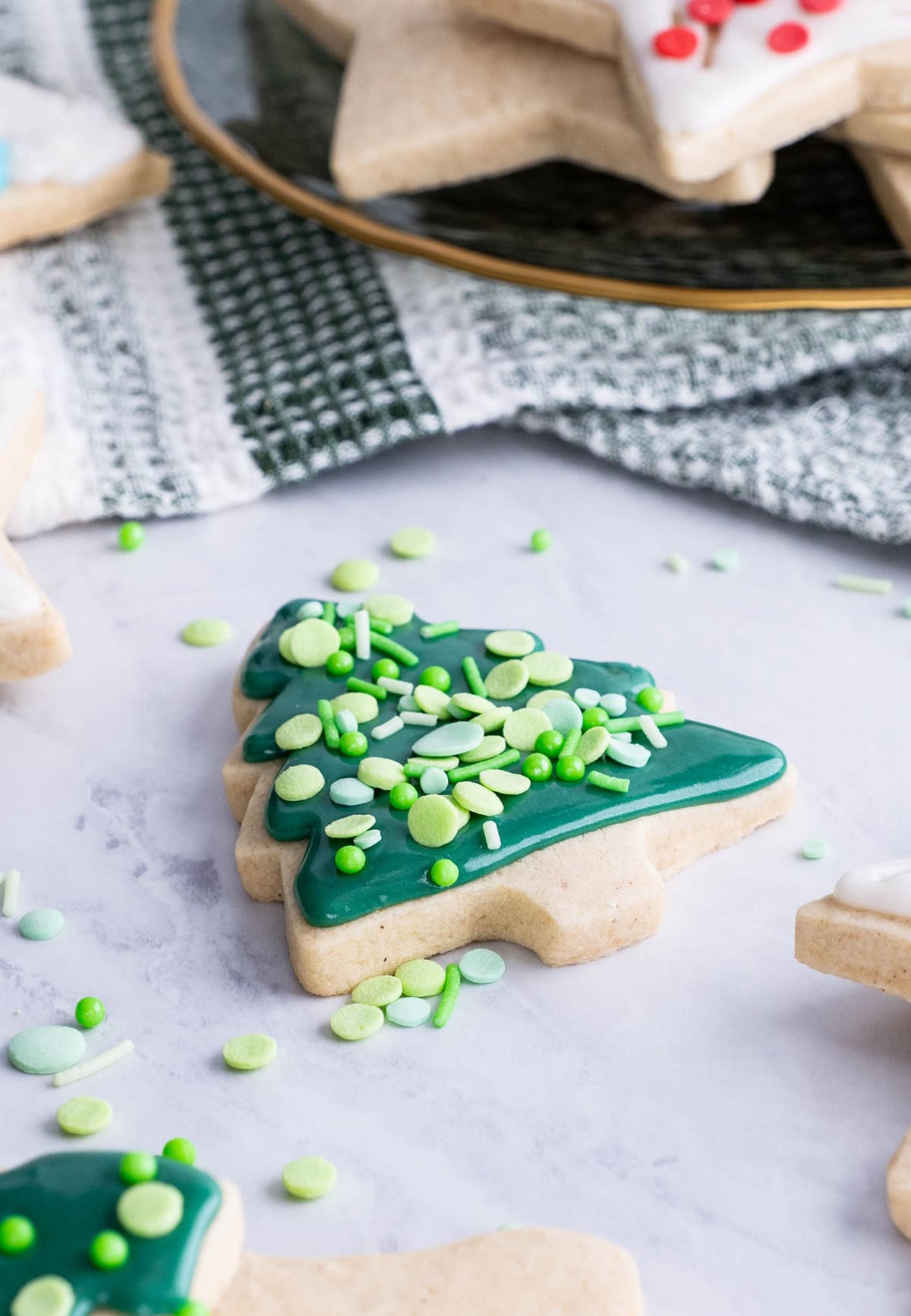 gluten-free sugar cookies on a marble surface, decorated into Christmas shapes.