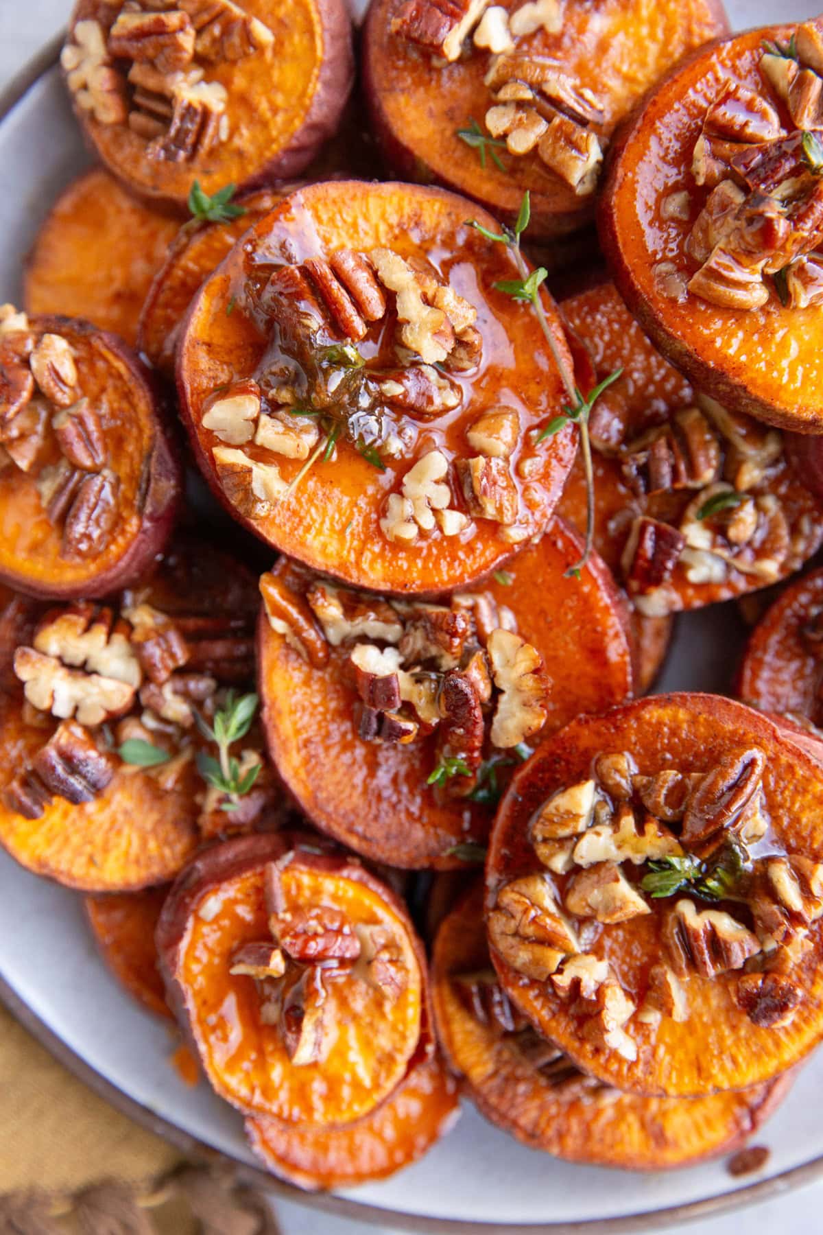 Plate stacked with melting potatoes with pecans and maple, ready to serve.