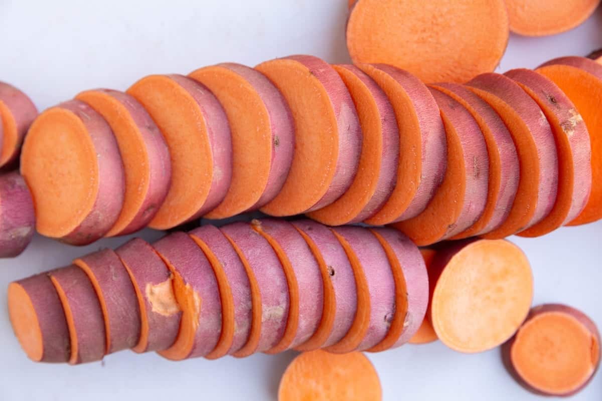 Sweet potato discs on a cutting board, cut into 1/4 inch pieces.