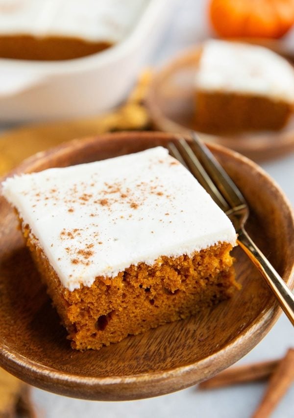 Two slices of pumpkin cake on wooden plates, ready to eat.