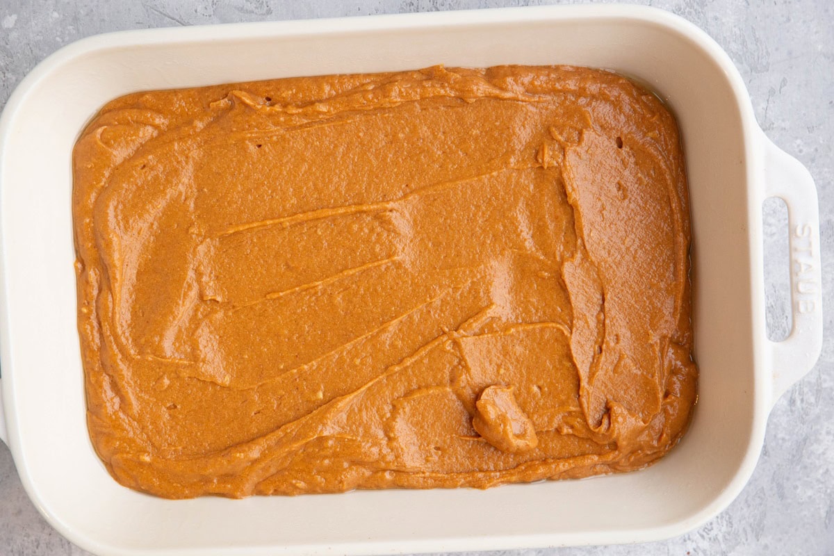 Pumpkin cake batter in a large casserole dish to make sheet cake.