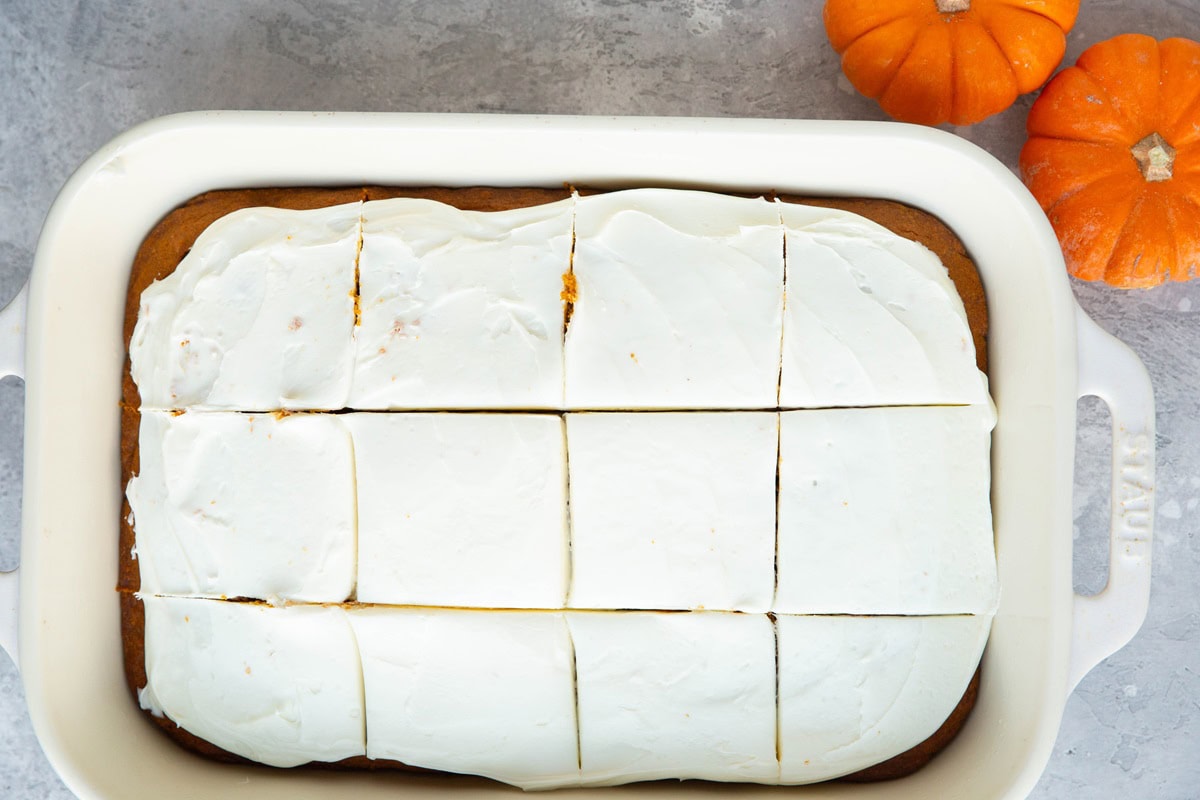 Pumpkin cake cut into slices in a large baking dish.