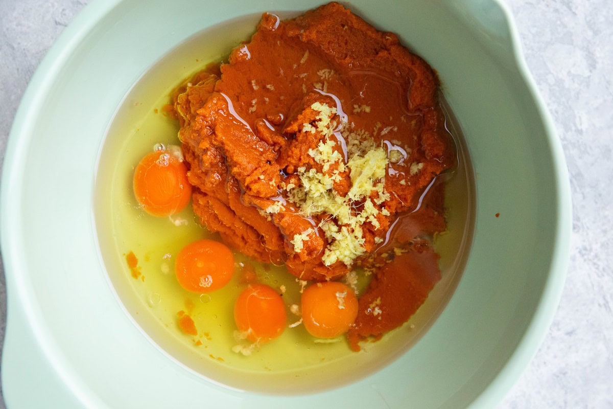 Wet ingredients for pumpkin cake in a mixing bowl.