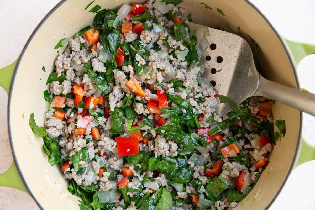 Large pot of sausage, onion, spinach, and bell pepper