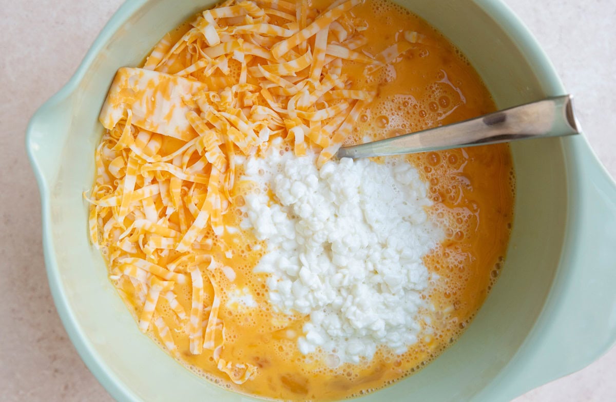 Beaten eggs, cheese, and cottage cheese in a mixing bowl. ready to mix together.