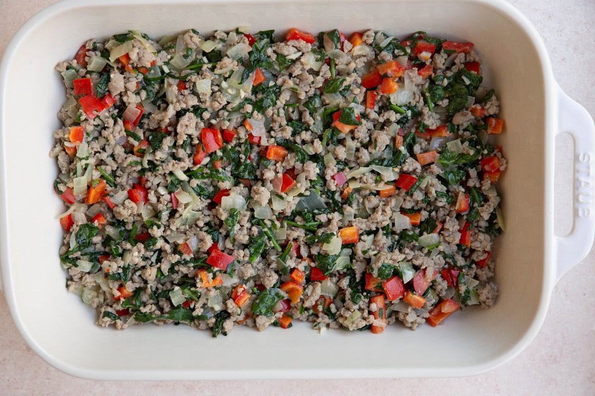 Large casserole dish full of sausage and vegetables.