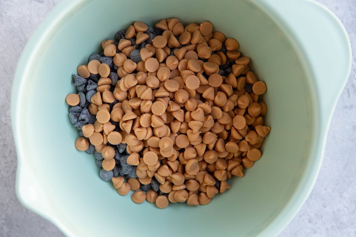 Large bowl with chocolate chips and butterscotch chips inside, ready to be melted in the microwave.