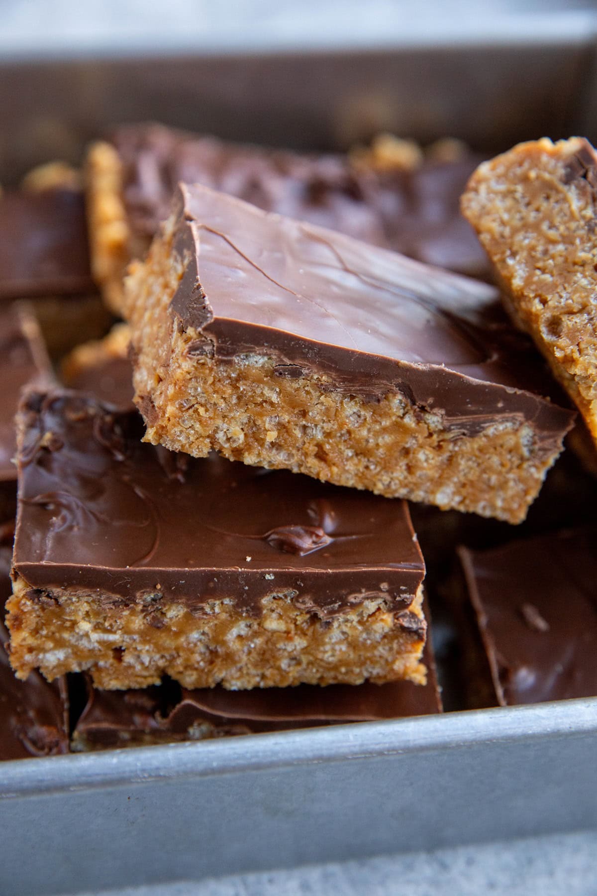 Pile of scotcheroos in a baking dish, cut into individual slices and ready to eat.