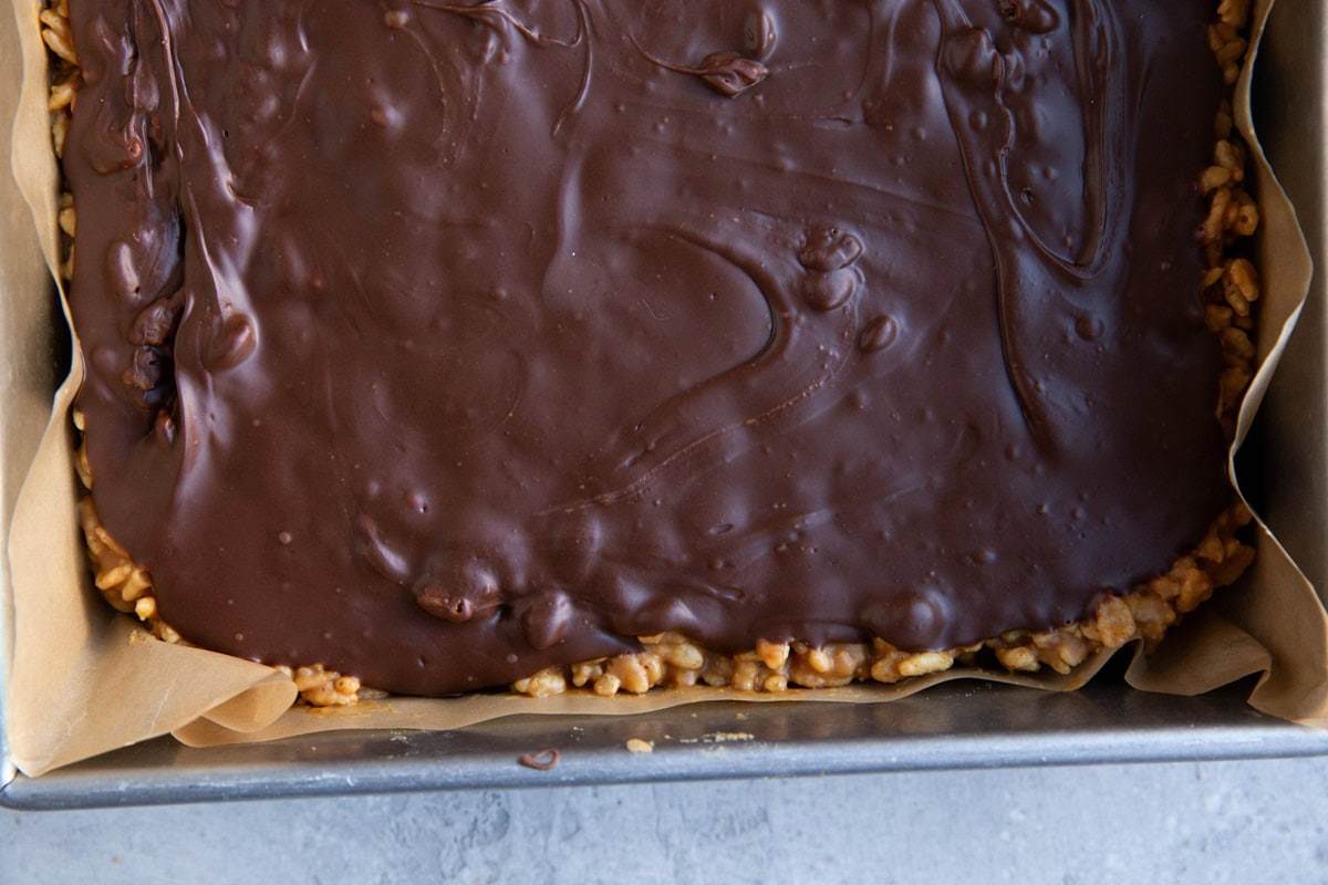 Scotcheroo bars in a pan, waiting to be cut into small pieces.