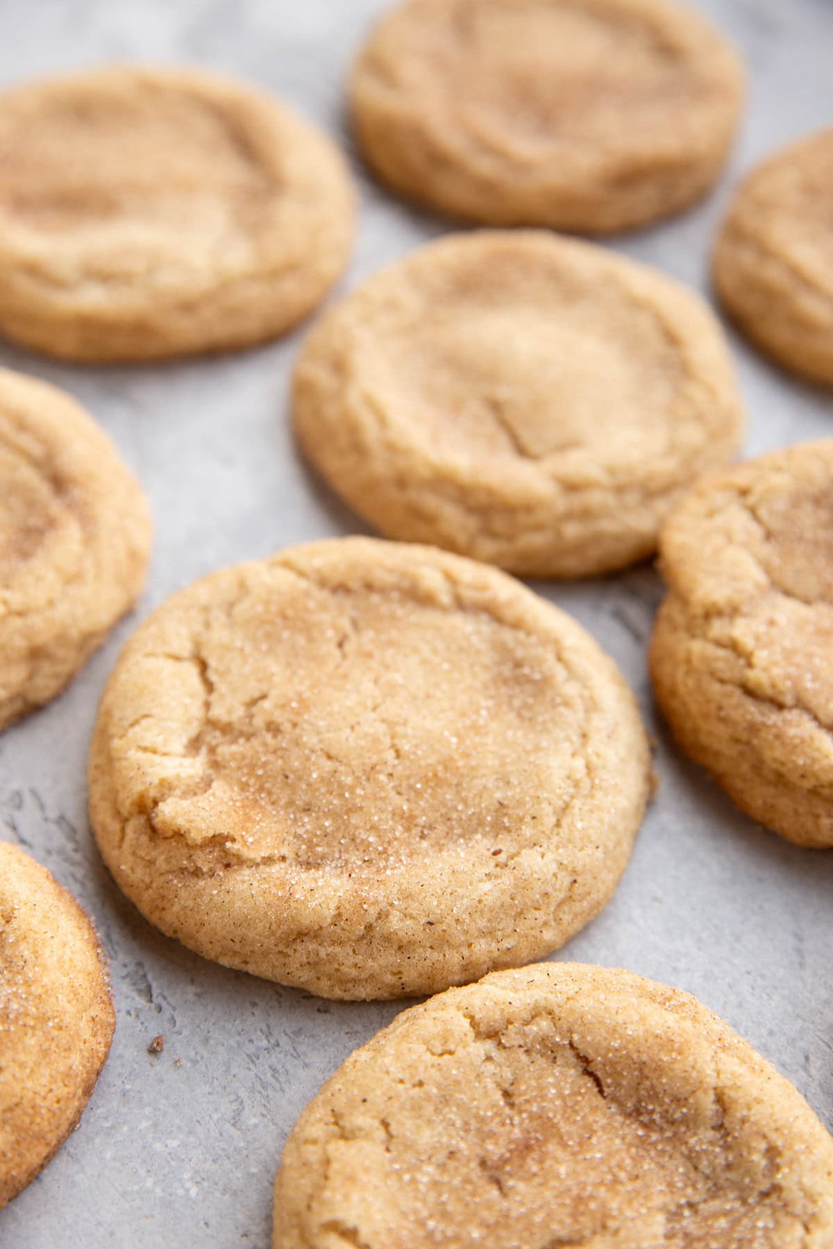 Snickerdoodles sitting on a marble background, ready to eat.