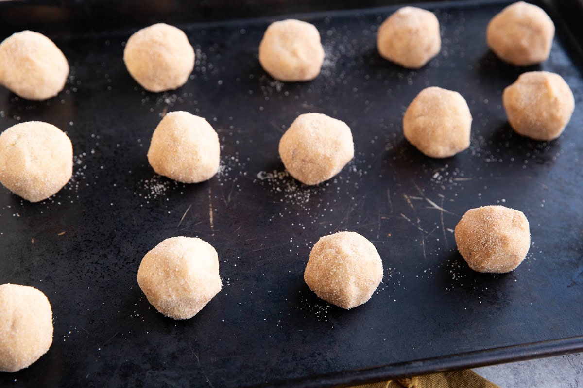 Cookie dough balls on a baking sheet.