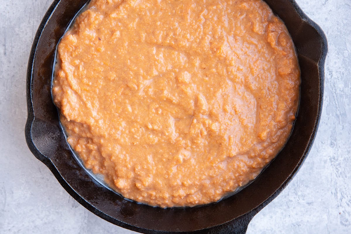 Layer of sweet potato mixture in a cast iron skillet