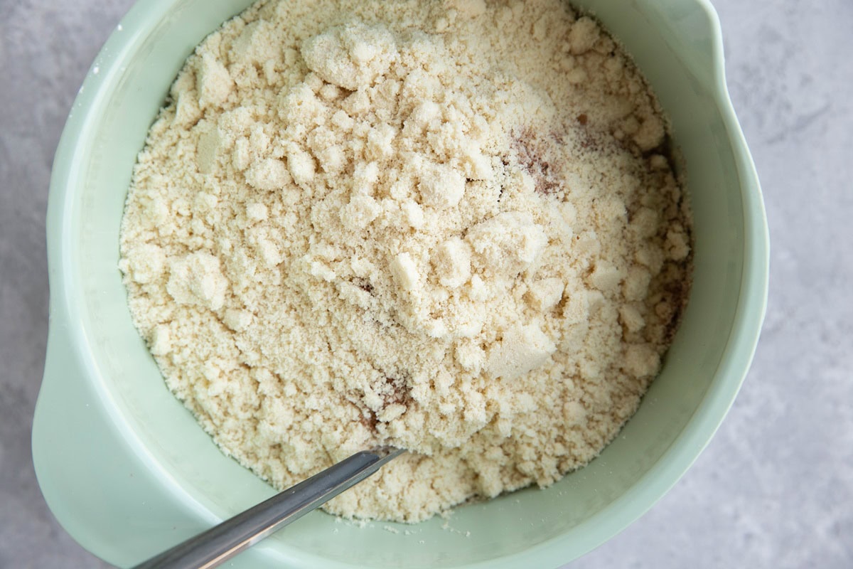 Mixing bowl with wet ingredients and dry ingredients on top to make grain free scones.