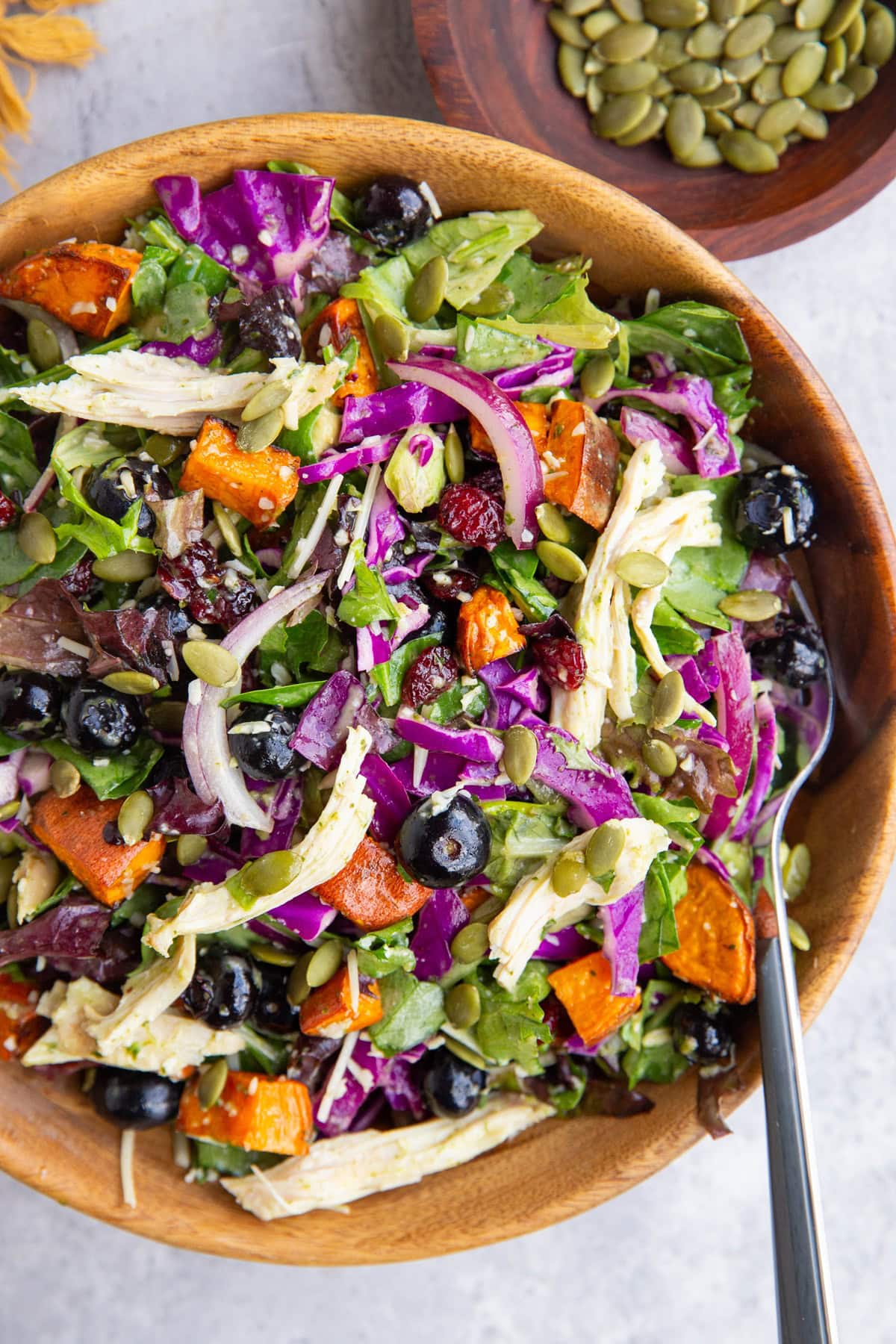 Large wood bowl with a huge winter salad inside