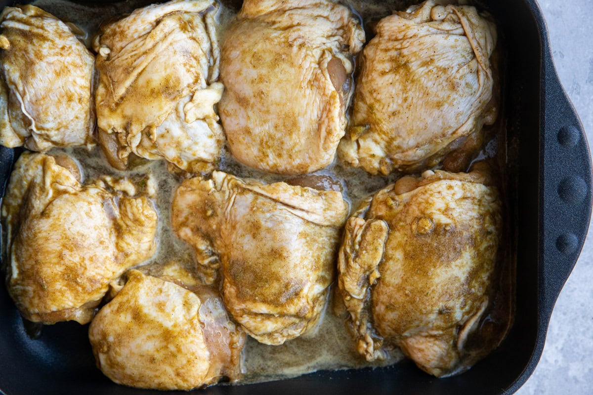 Marinated jerk chicken in a large casserole dish, ready to bake in the oven.