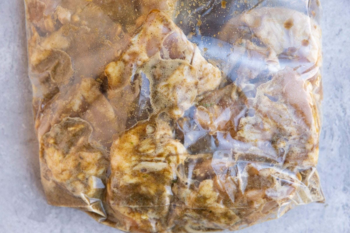 Large zip lock bag full of chicken thighs with marinade inside.