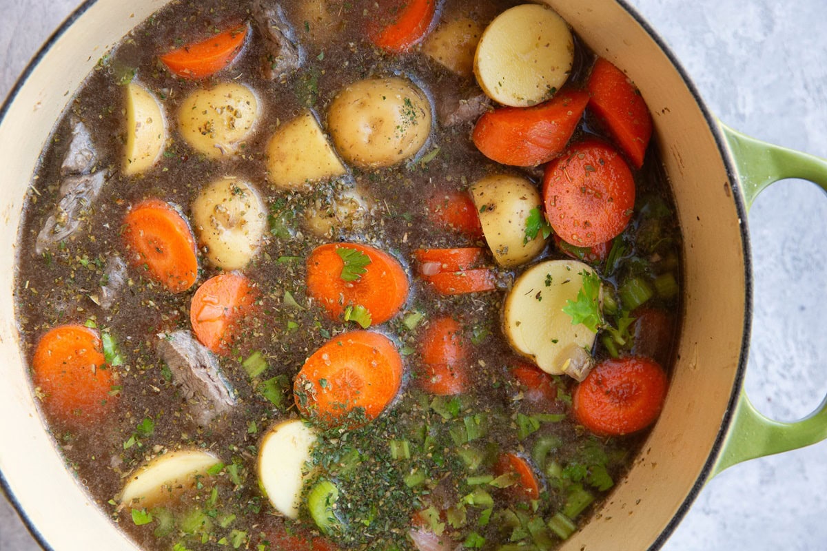 Large pot of beef stew ingredients, ready to be boiled.