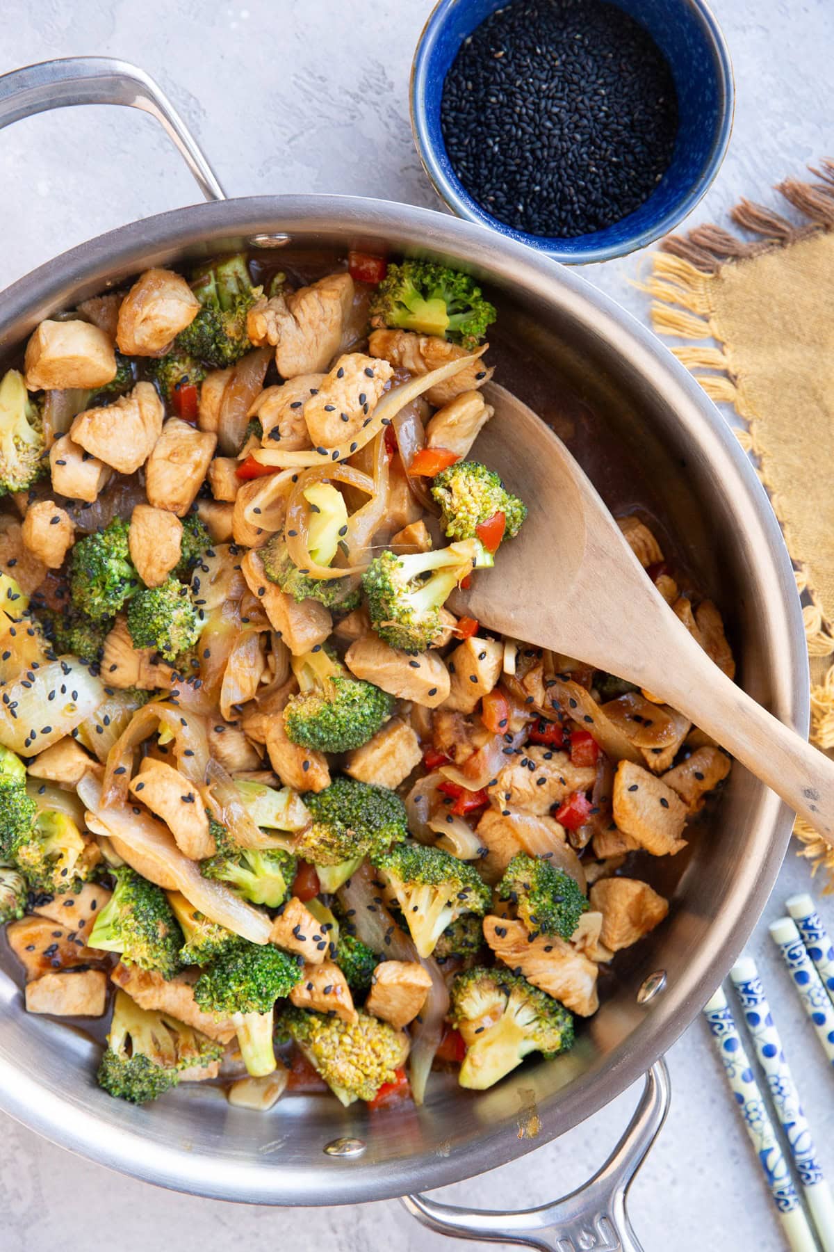 Stainless steel skillet full of chicken and broccoli stir fry.