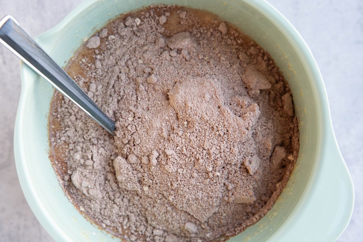 Mixing bowl with wet ingredients mixed together and the dry ingredients on top.