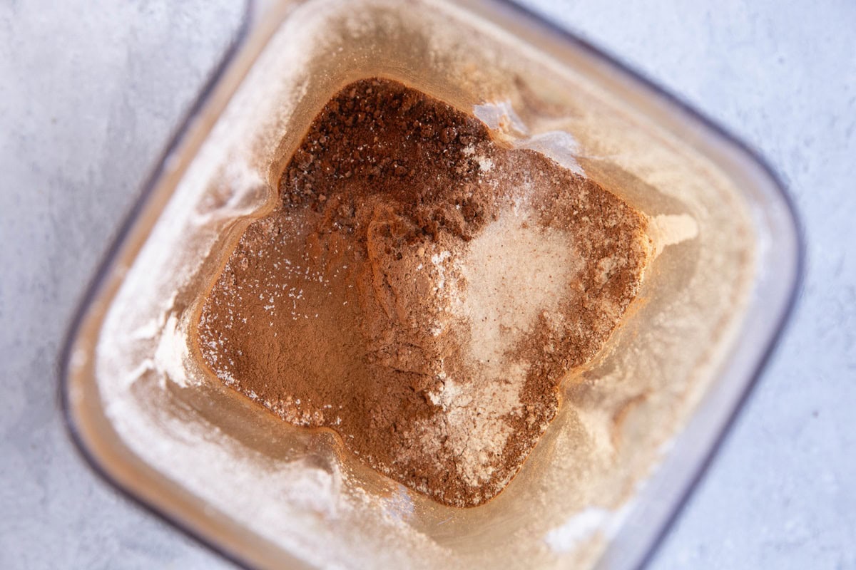 Dry ingredients in a blender to make chocolate muffins.