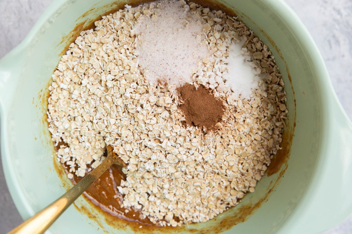 Wet ingredients in a mixing bowl with dry ingredients on top, ready to be mixed.