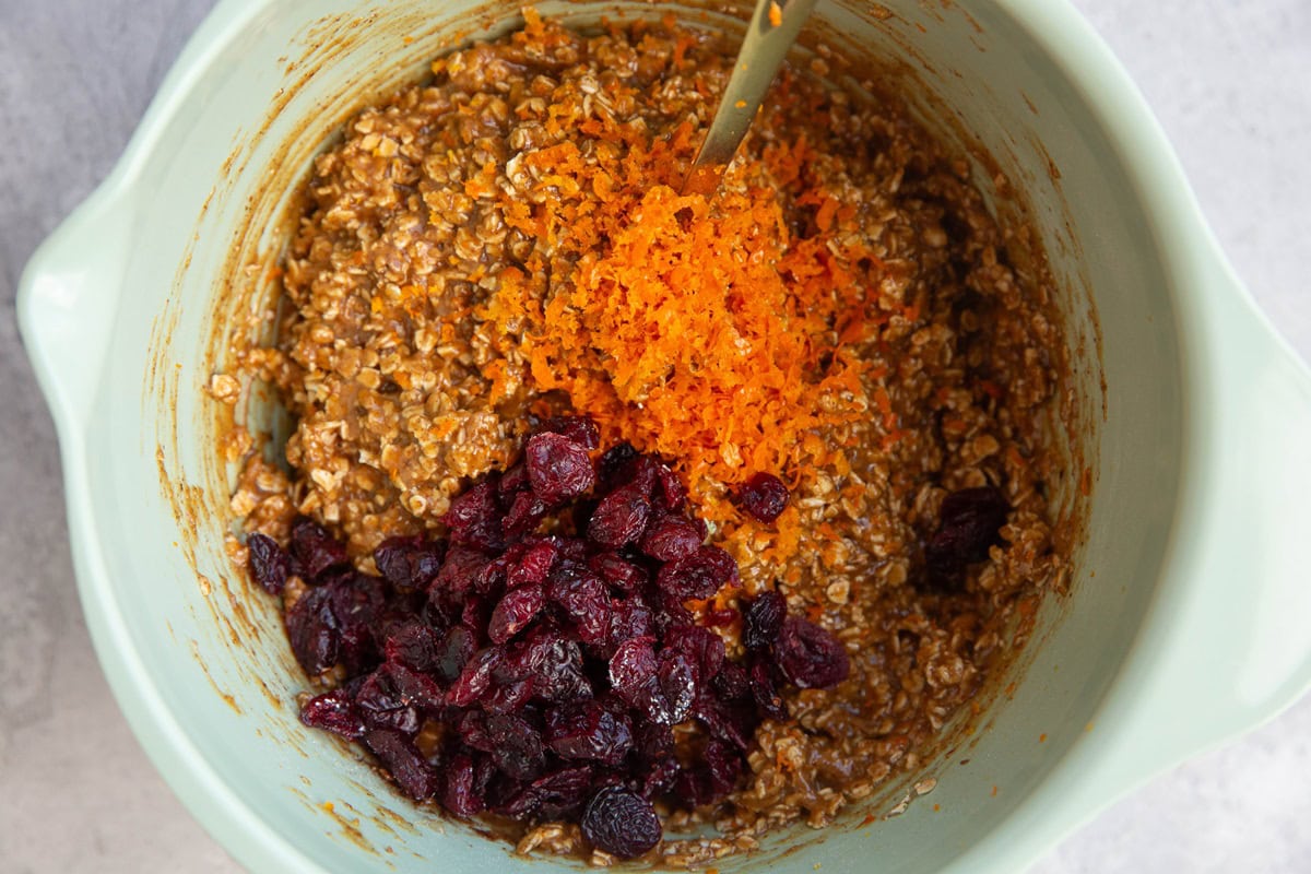 Mixing bowl with orange zest and dried cranberries on top.