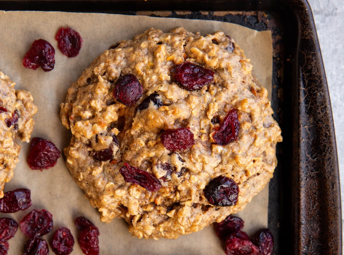 Cranberry orange cookie on a baking sheet, fresh out of the oven.