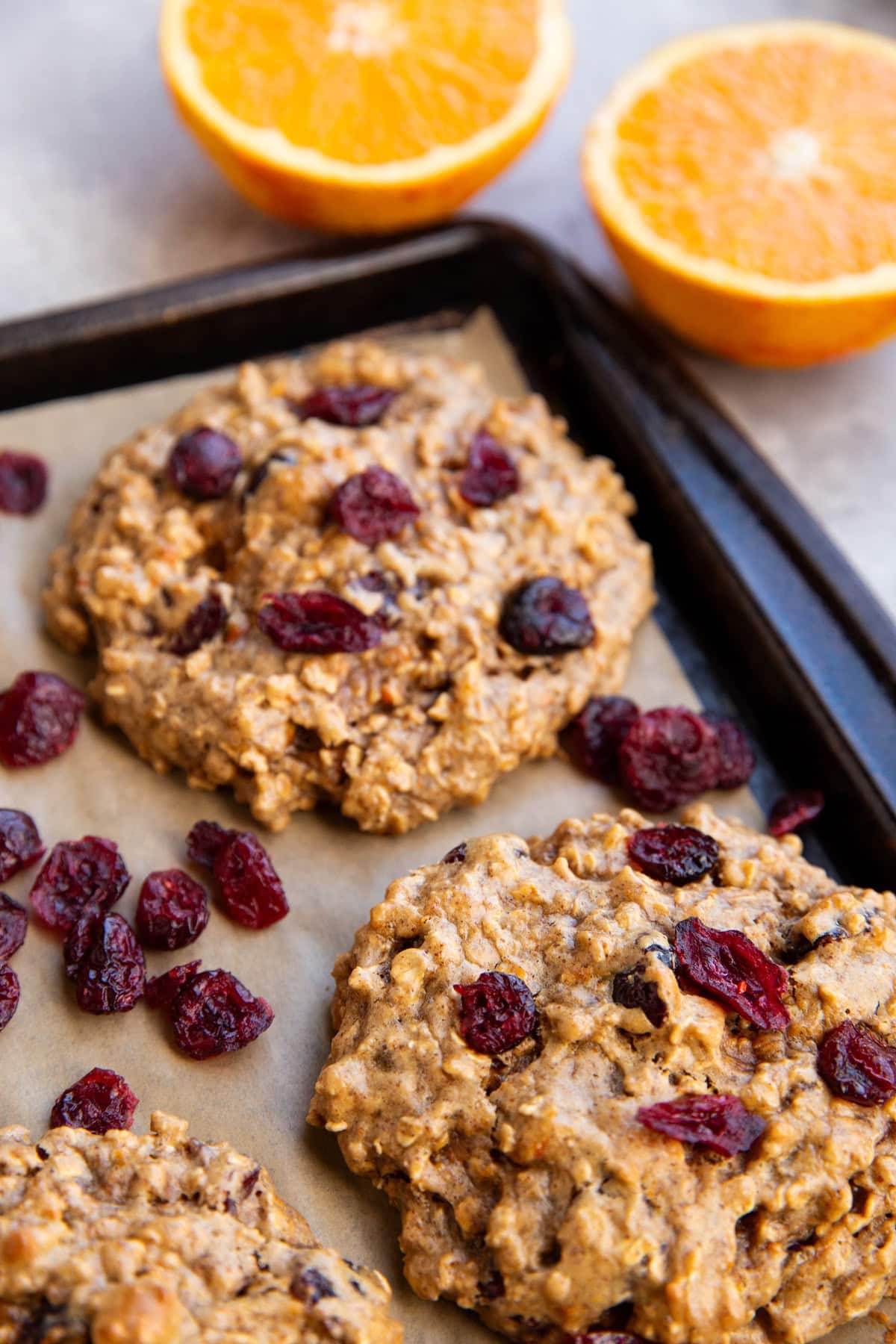 Large baking sheet with large cranberry orange cookies on top.