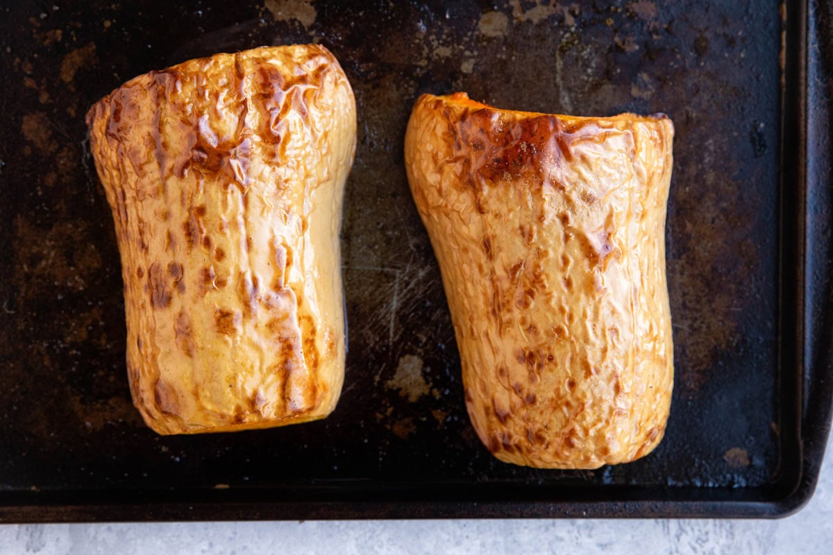 Roasted butternut squash on a baking sheet, fresh out of the oven and fully cooked.