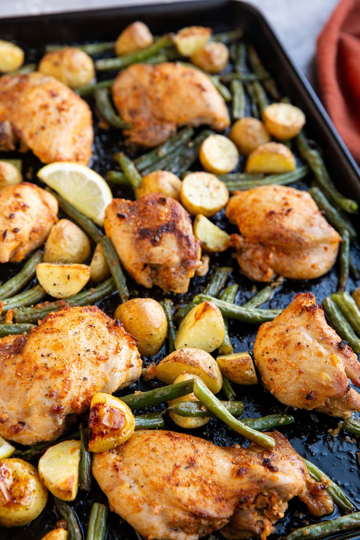 Large sheet pan full of chicken and vegetables, ready to eat for dinner.