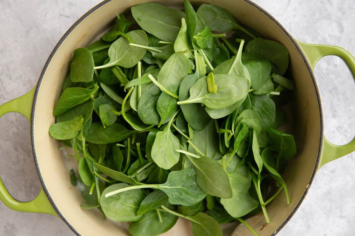 Large pot of coconut chicken with fresh baby spinach added in.