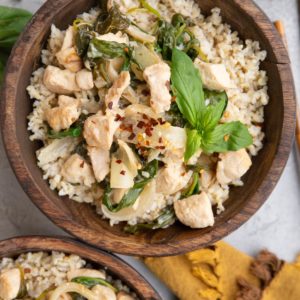 Two big wooden bowls full of coconut chicken and rice.