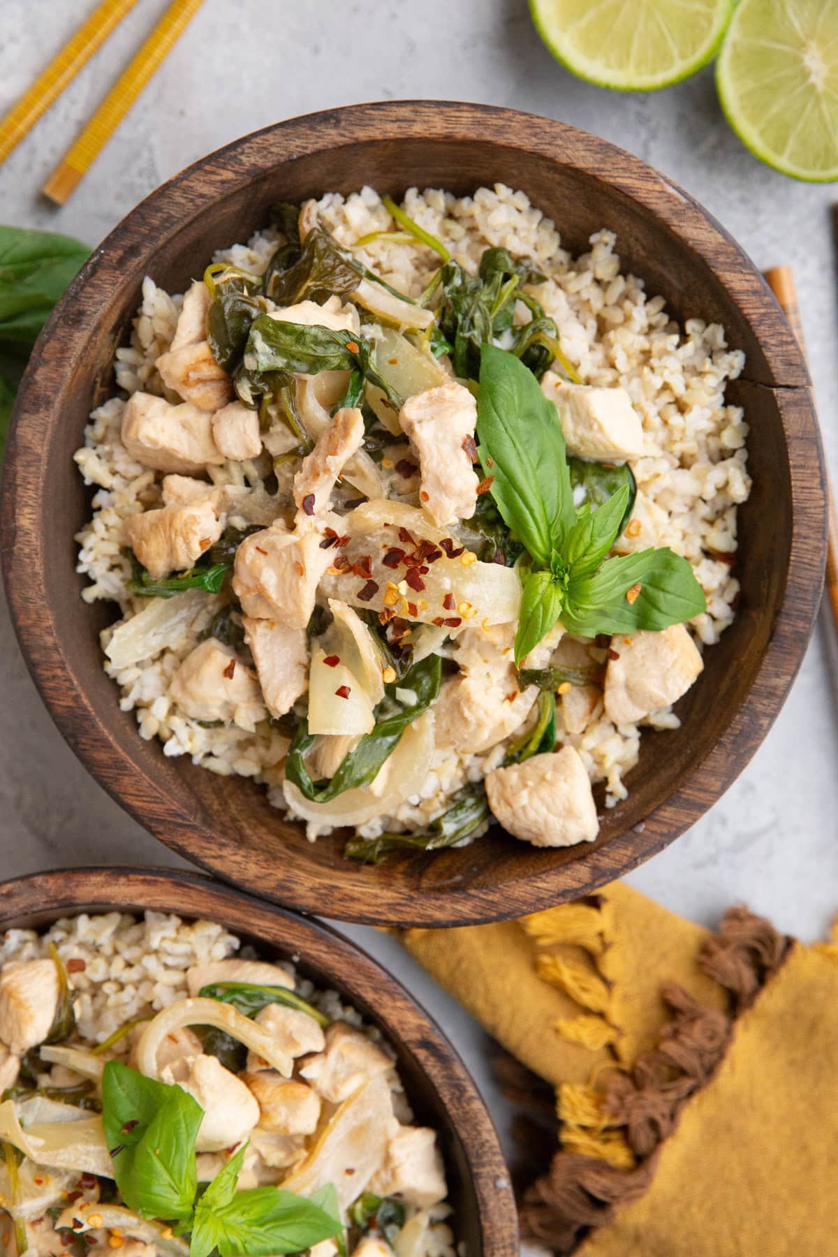 Two big wooden bowls full of coconut chicken and rice.