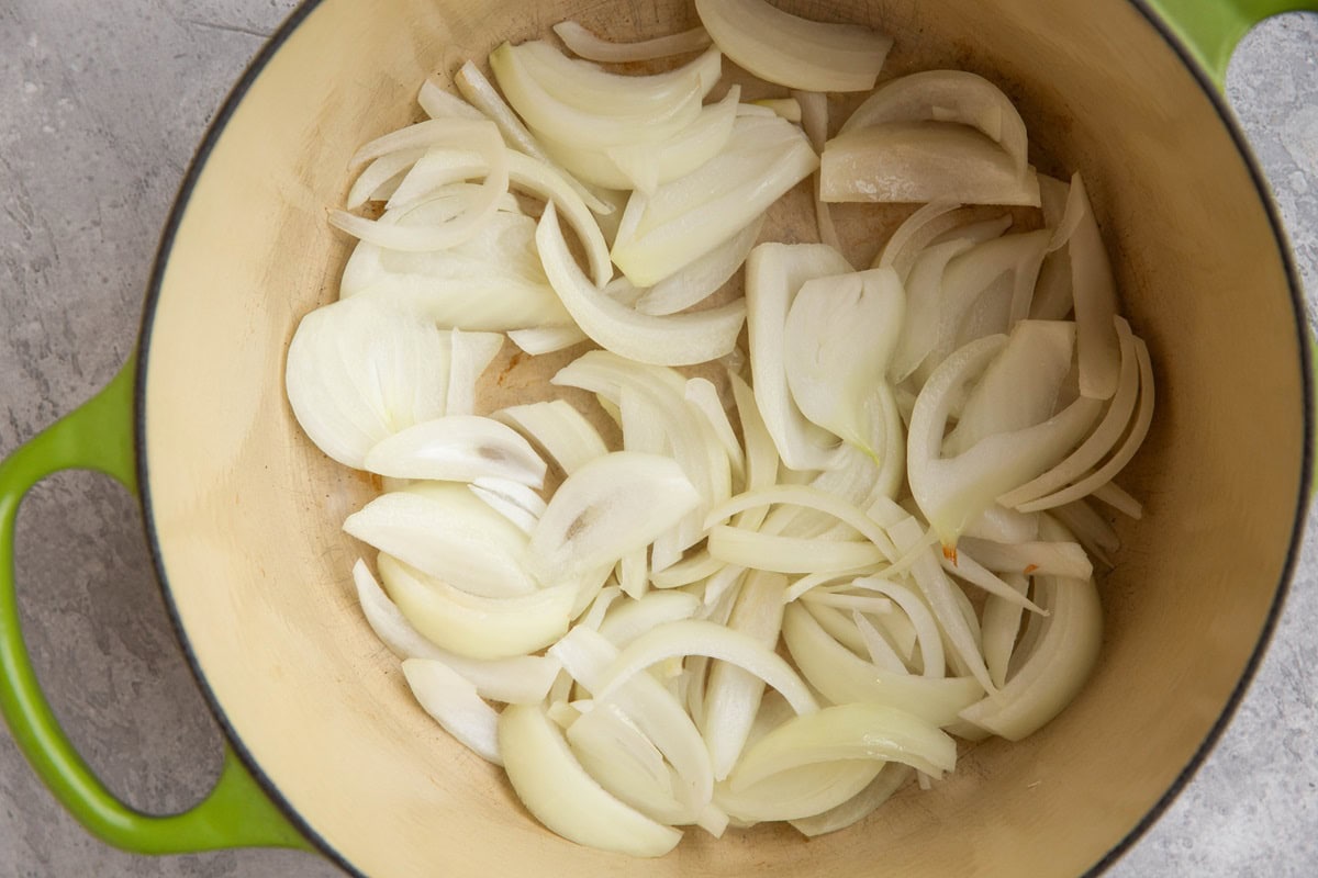 Onions cooking in a large pot to make coconut chicken.