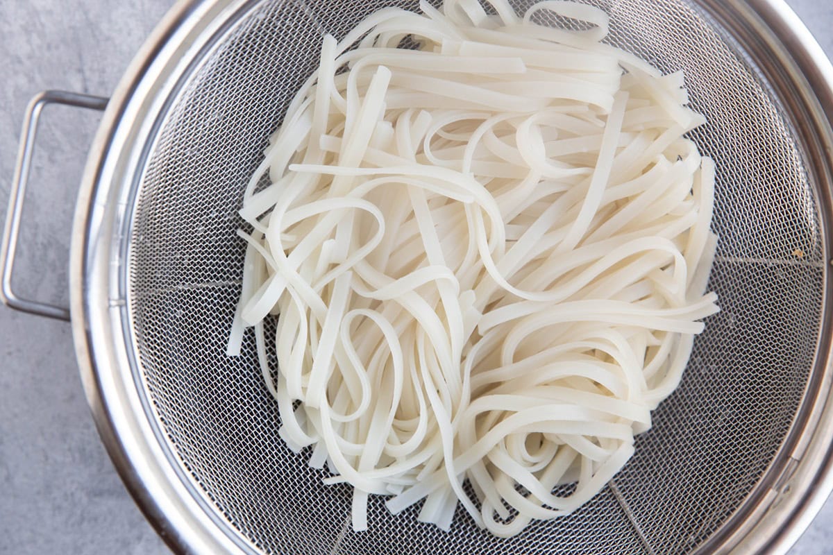 Colander full of rice noodles, fully cooked and ready to use.