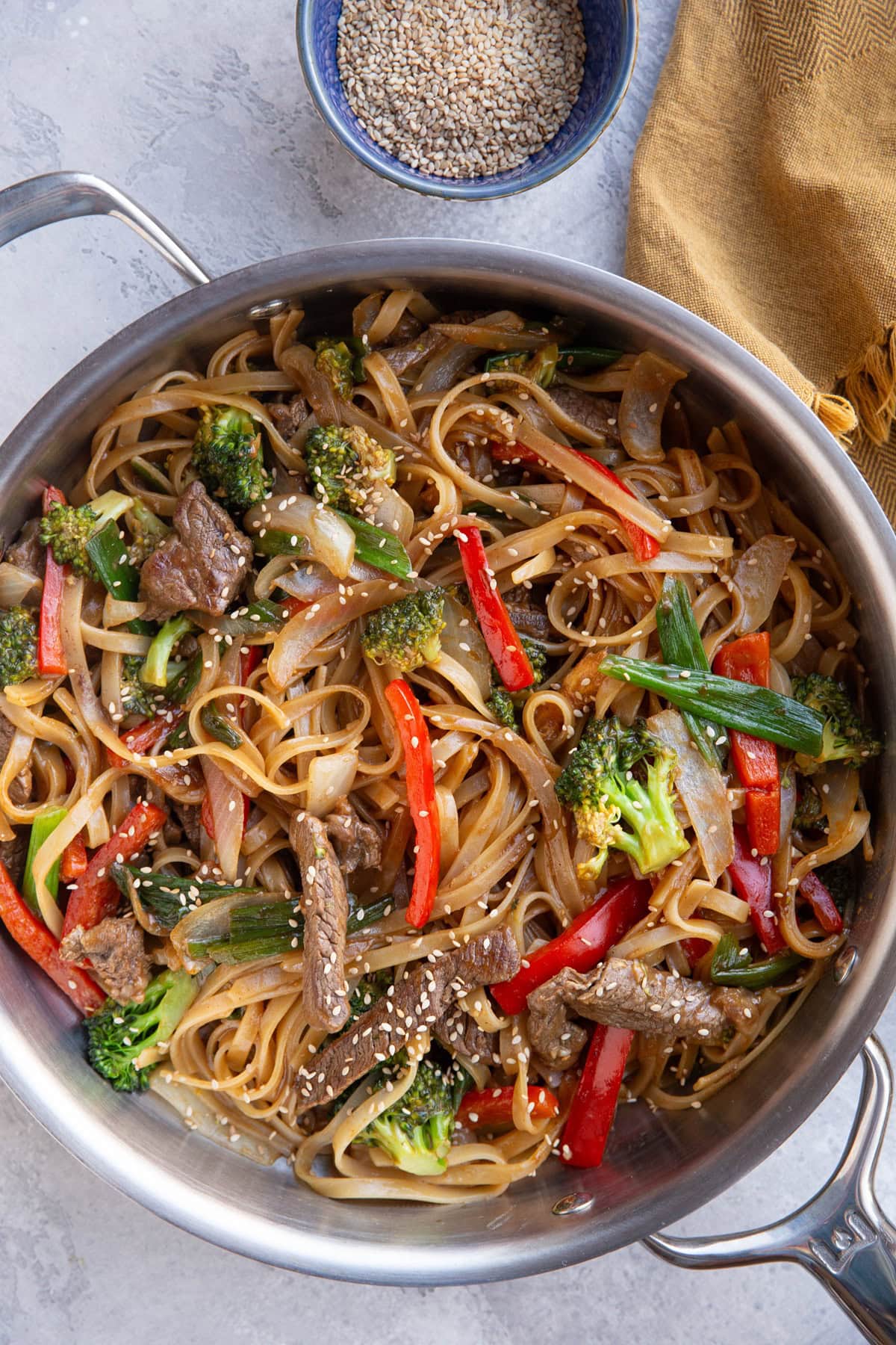 Stainless steel skillet with saucy noodles, beef and vegetables. Finished and ready to serve.