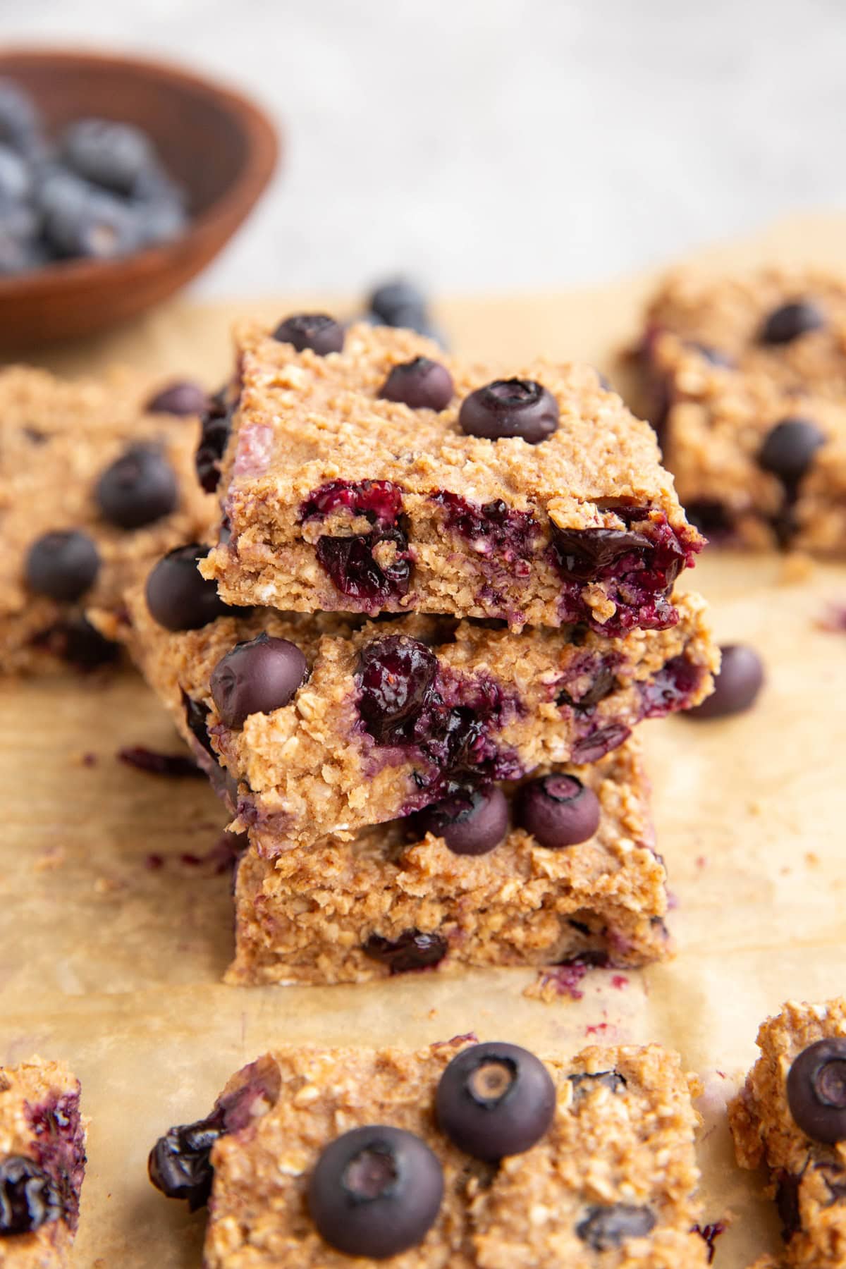 Stack of blueberry oatmeal bars, with the gooey blueberries showing.