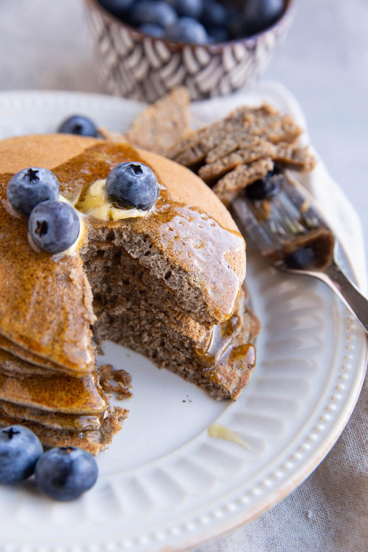 Stack of buckwheat pancakes with a bite taken out.