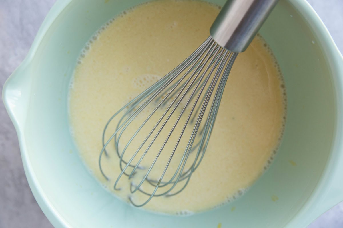 Mixing bowl with wet ingredients whisked together for pancakes.