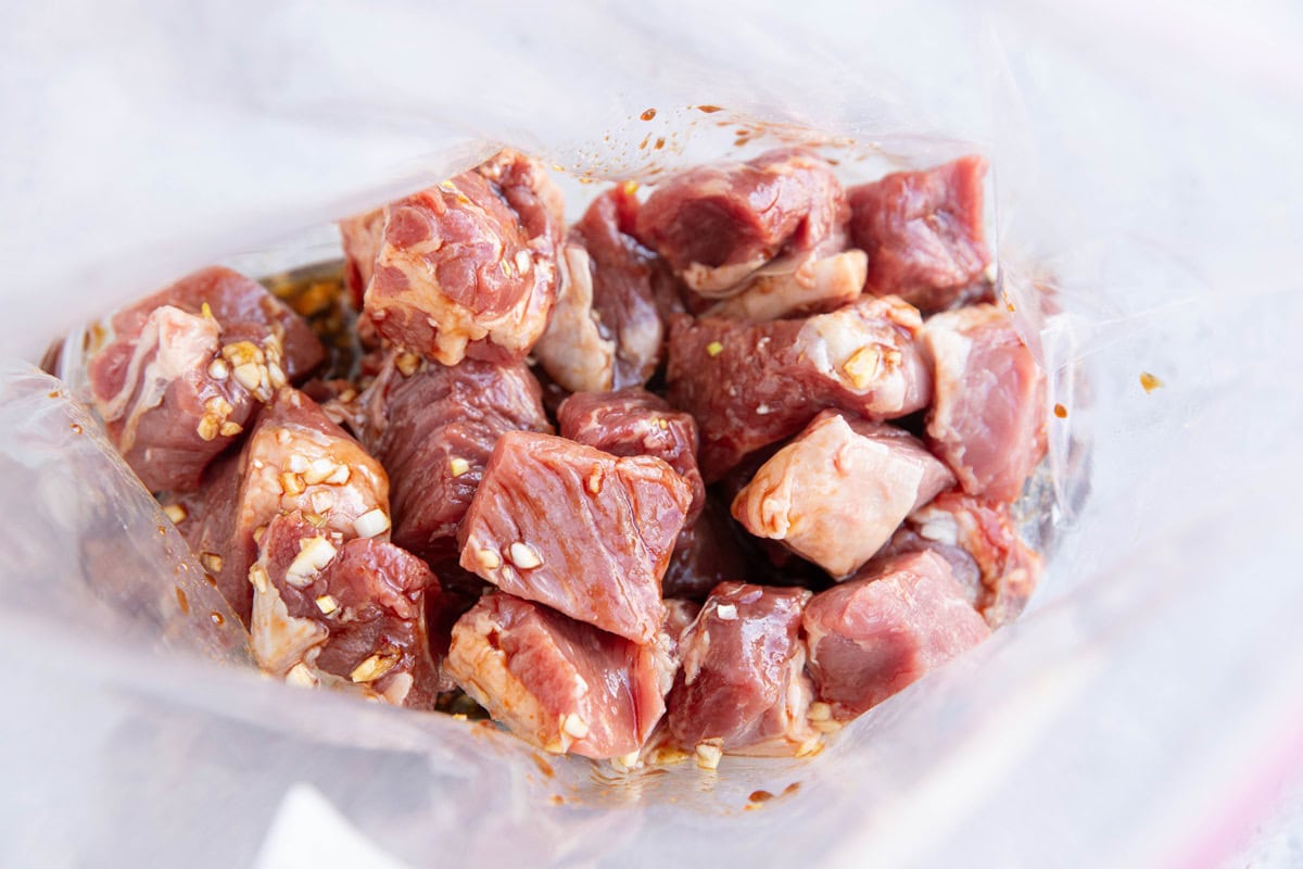 Large zip lock bag full of chopped steak bites and marinade.