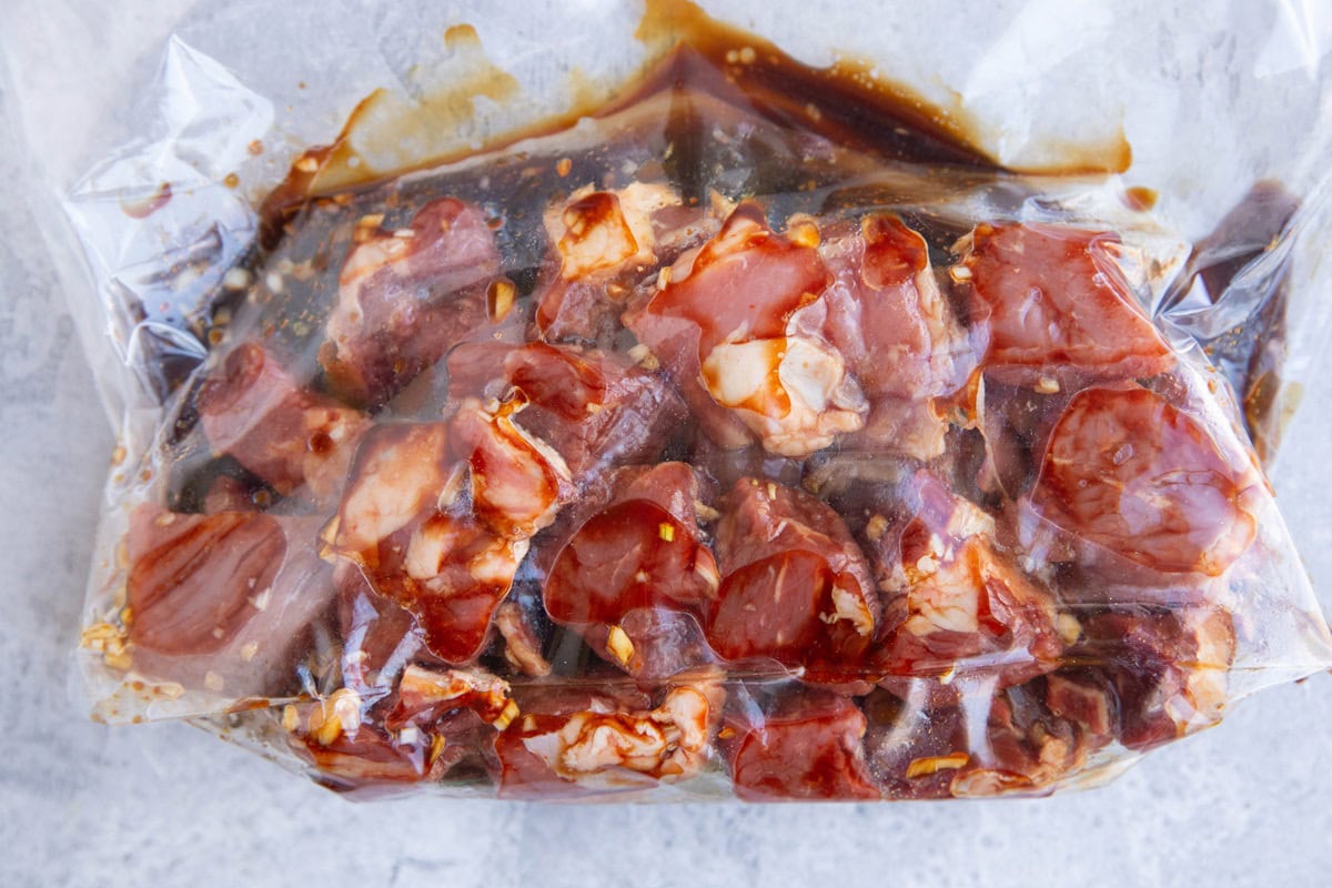 Large zip lock bag full of marinated steak bites.