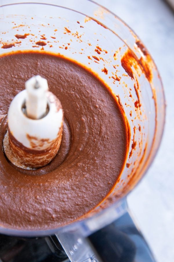 Food processor full of chocolate sweet potato frosting, ready to be used.