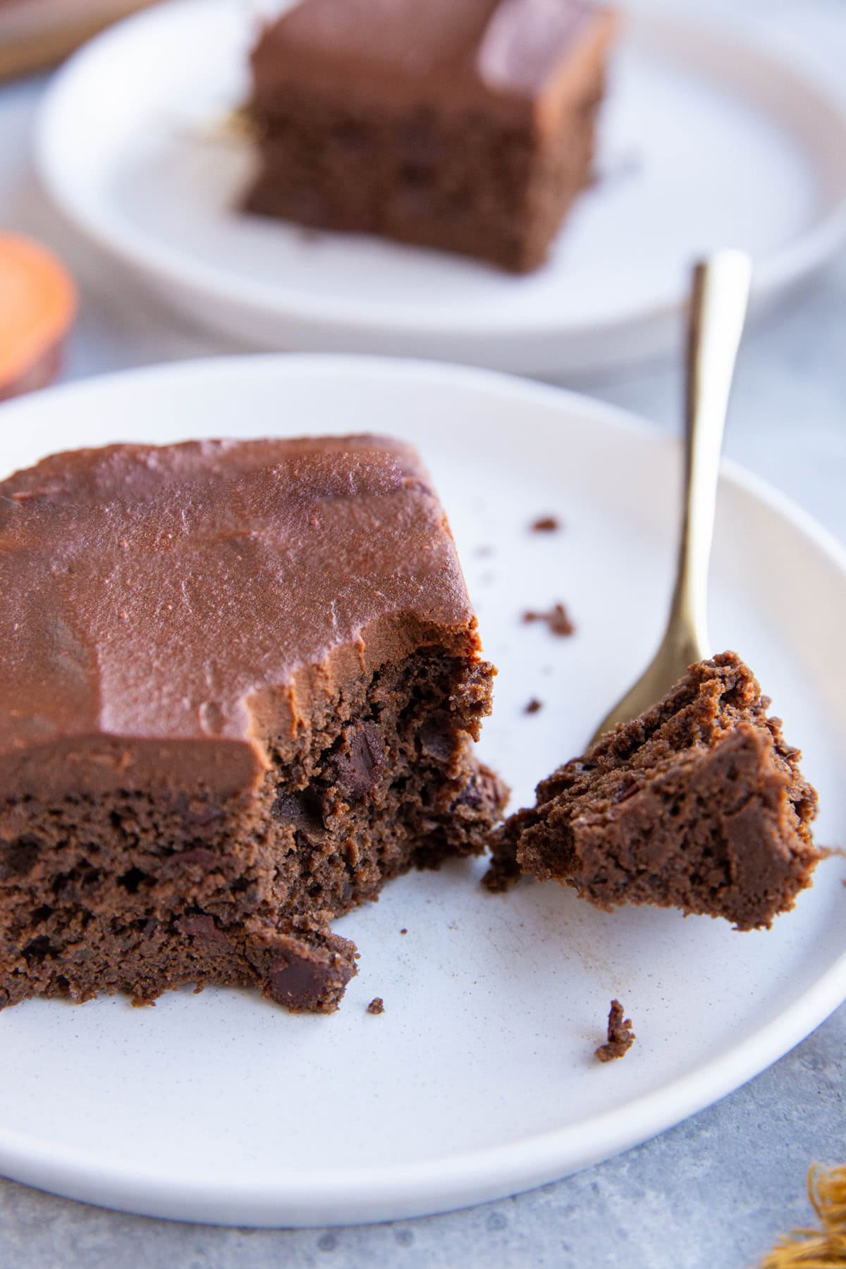 Chocolate cake with chocolate frosting with a bite taken out.